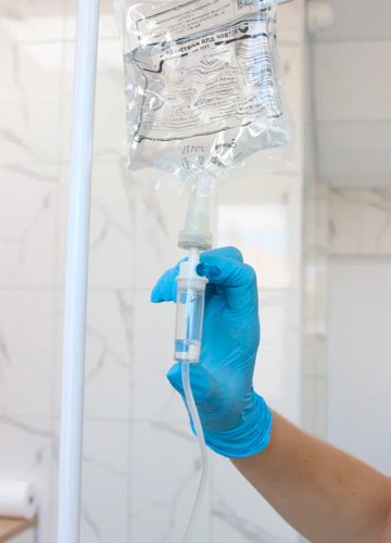 Врач поправляет капельницу